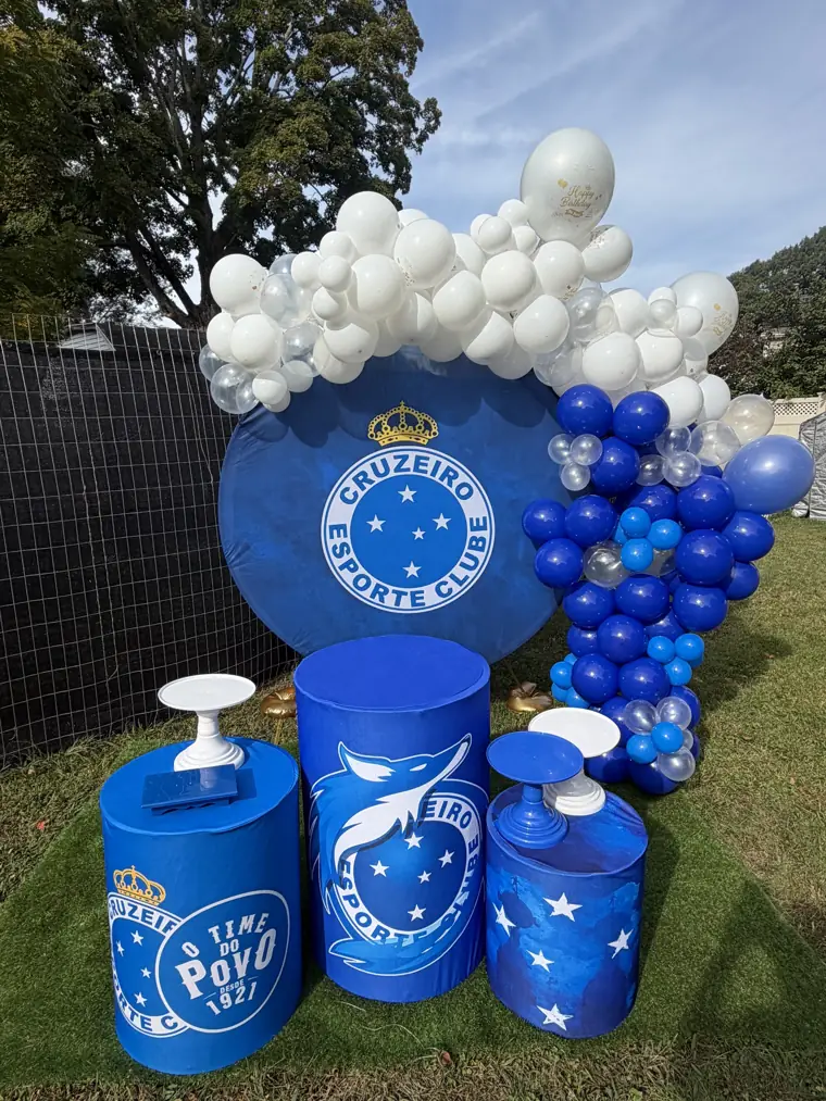 Decoração montada pela Party Decoration Fest no tema Time de futebol: painel, arco de balões e cilindros com bandejas
