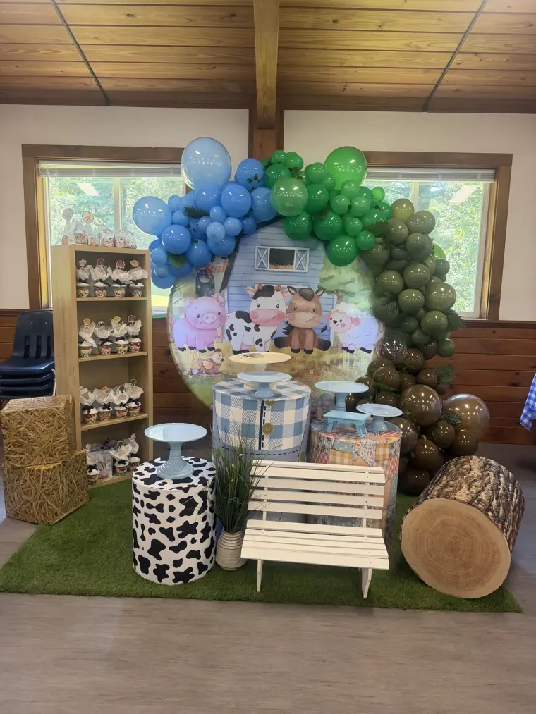 Decoração montada pela Party Decoration Fest no tema Fazendinha: painel, arco de balões e cilindros com bandejas