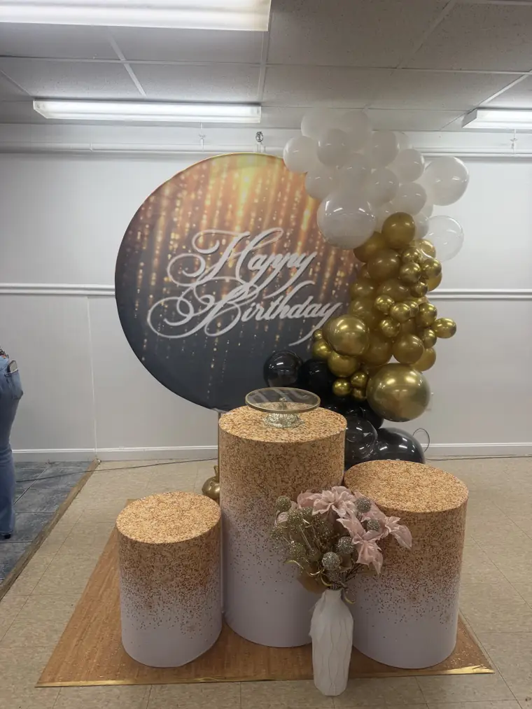 Decoração montada pela Party Decoration Fest no tema Happy birthday preto e dourado: painel, arco de balões e cilindros com bandejas