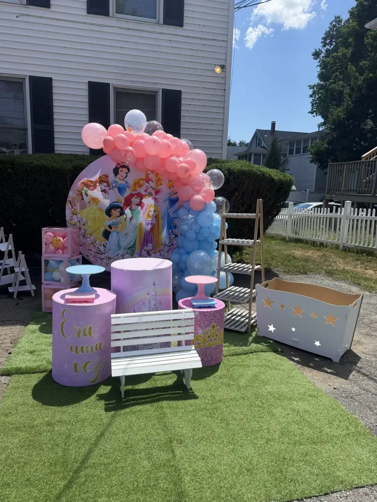 Decoração montada pela Party Decoration Fest no tema Princesas no quintal: painel, arco de balões e cilindros com bandejas