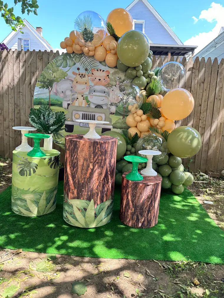Decoração montada pela Party Decoration Fest no tema Safári de jipe: painel, arco de balões e cilindros com bandejas