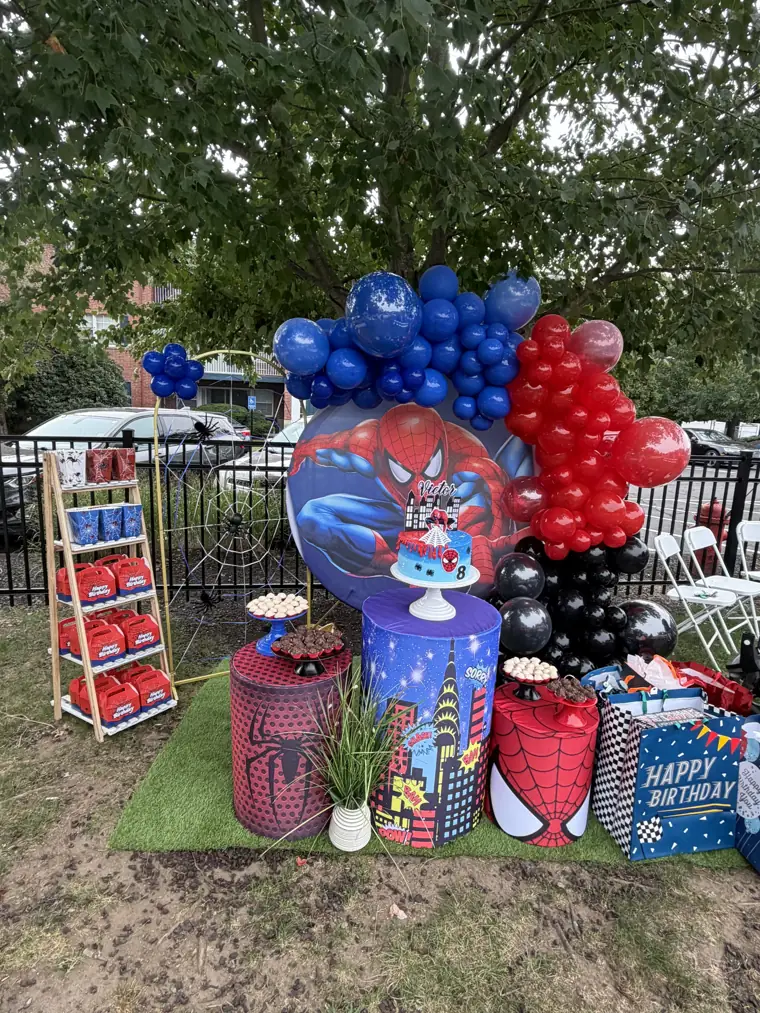 Decoração montada pela Party Decoration Fest no tema Homem-Aranha: painel, arco de balões e cilindros com bandejas
